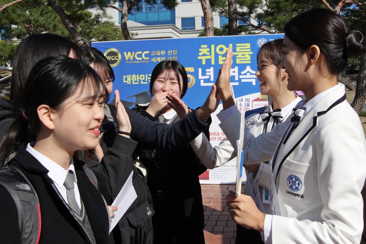 구미대 홍보대사 ‘키우미’ 학생들과 면접생들이 ‘하이파이브’를 하고 있다.