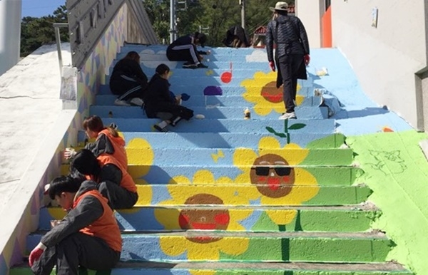 호남대 미술학과 학생들이 양산동 계단 벽화를 단장하고 있다.
