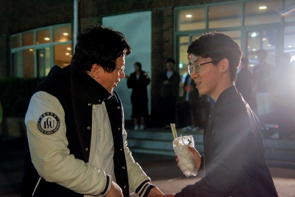 장순흥 총장이 야식을 학생들에게 나눠주며 응원과 격려의 인사를 건네고 있다.