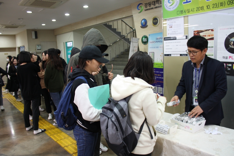 도서관 직원들이 중간고사를 준비하기 위해 일찍 등교한 학생들에게 김밥을 전달하고 있다.