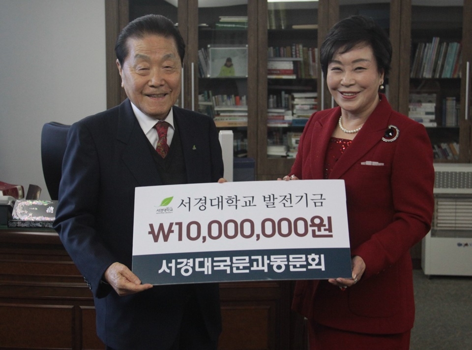 김길연 동문회장이 최영철 총장(왼쪽)에게 발전기금을 전달하고 있다.