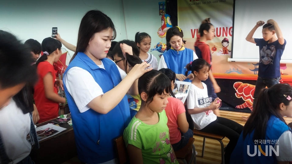 경북전문대학교 뷰티케어과 학생이 해외에서 교육기부 봉사활동으로 외국 어린이들에게 미용봉사를 하고 있다.