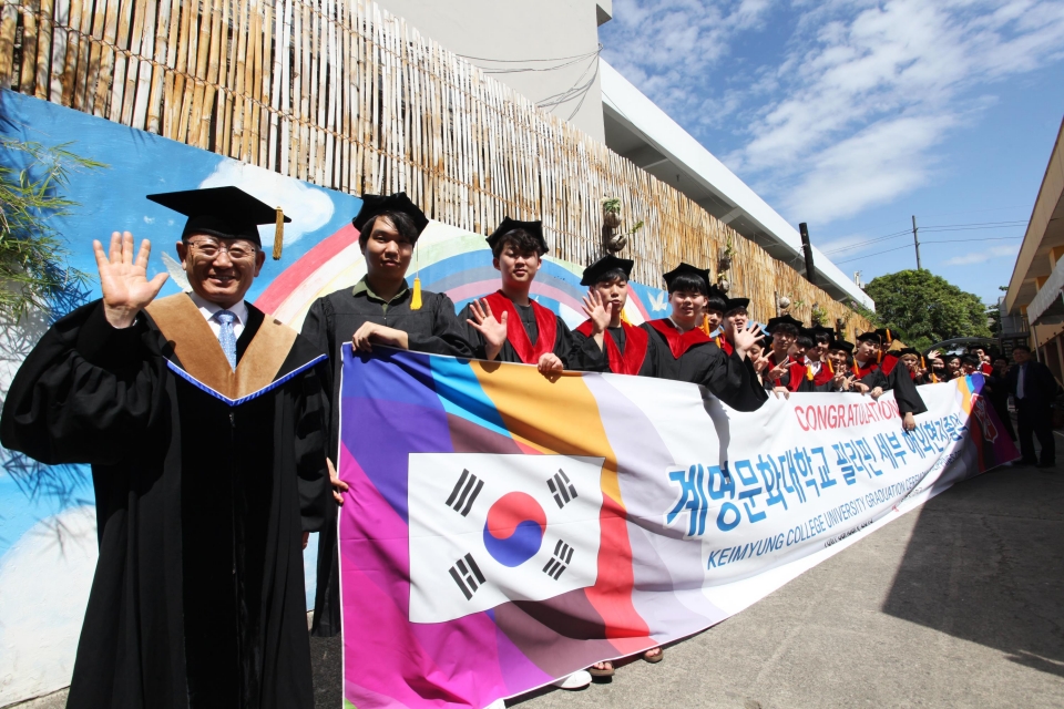 박명호 총장(왼쪽)이 계명문화대학교 졸업생들과 해외 현지 졸업식 후 기념 촬영을 하고 있다.