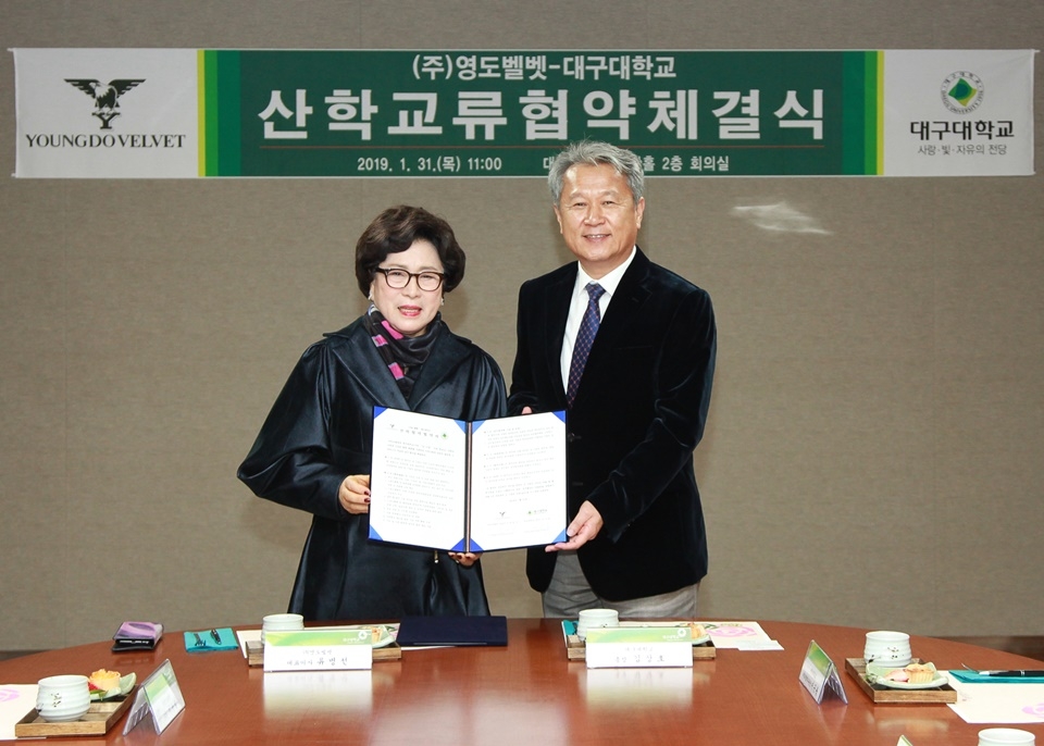 31일 산학교류 협약 체결식에서 류병선 영도벨벳 회장(왼쪽)과 김상호 총장(오른쪽)이 협약 체결 후 기념사진을 찍고 있다.