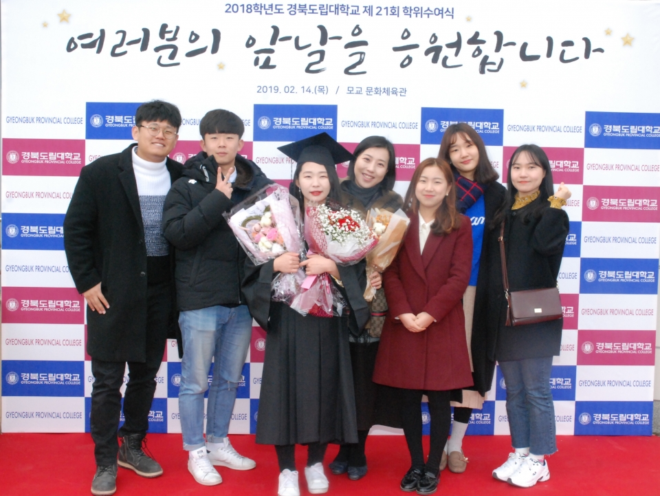 제21회 경북도립대학교 졸업생이 학사모를 쓰고 친구들과 함께 기념 촬영을 하고 있다.