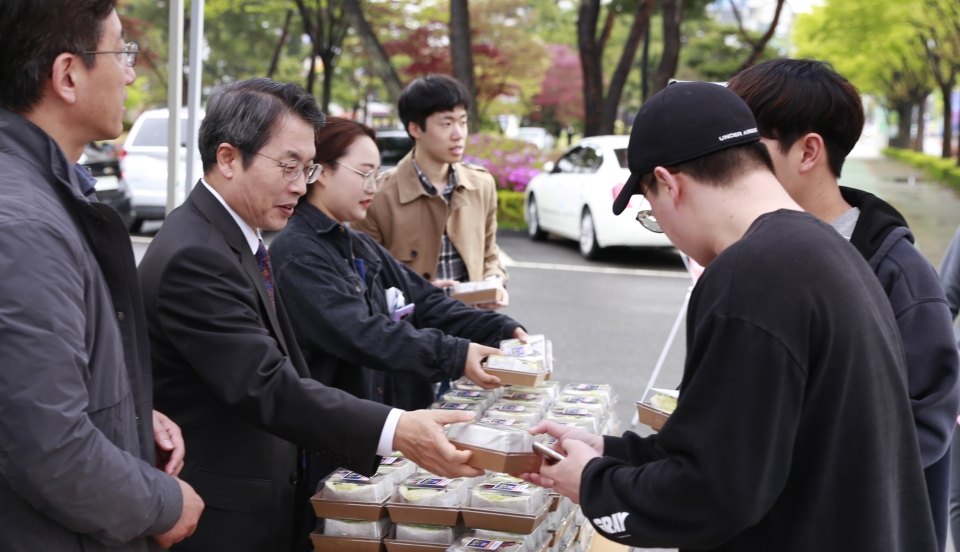 곽병선 총장이 '중간고사 천원 밥상 행사'에 참가해 학생에게 간편식을 천원에 판매하고 있다.