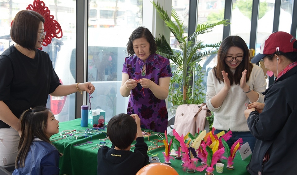 ‘중국의 매듭만들기 체험’에 참가한 초등학생들에게 원어민 교수가 직접 설명하면서 즐거워하고 있다.