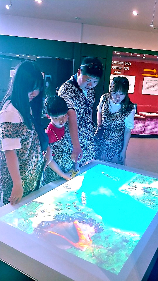 공주시의 대표 축제인 ‘공주 석장리 구석기축제’가 지난 3일~6일까지 열린가운데 공주 석장리박물관이 주최한 이번 특별 기획전이 축제에서 특별프로그램으로 운영됐다.주제는 “바다를 건넌 선사인들”로 전시주제의 효과적 전달을 위해 김정기 순천향대 디지털애니메이션학과 교수와 학생들이 ㈜시온네트웍과 협력으로 3D미디어를 제작했다. 구서기 시대 복장을 한 가족이 테이블에 프로젝션된 3D미디어 영상을 통해 관람하고 있다.