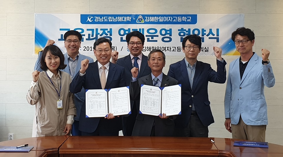 교육과정 연계협약식에서 홍덕수 총장(앞줄 왼쪽 두번째)과 김진곤 교장이 양교 관계자들과 파이팅을 하고 있다.
