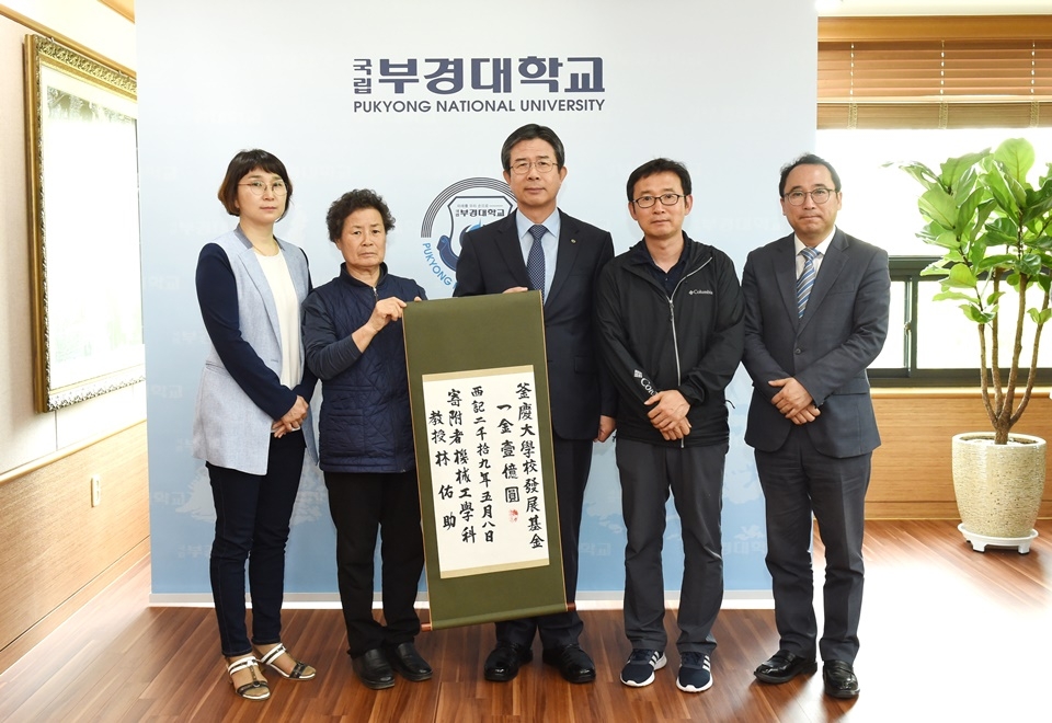고 임우조 교수의 부인 김윤자 씨(왼쪽 두 번째)와 장남 임진영 씨(맨 오른쪽) 등 가족들이 김영섭 총장(가운데)에게 발전기금을 전달하고 사진을 찍고 있다.