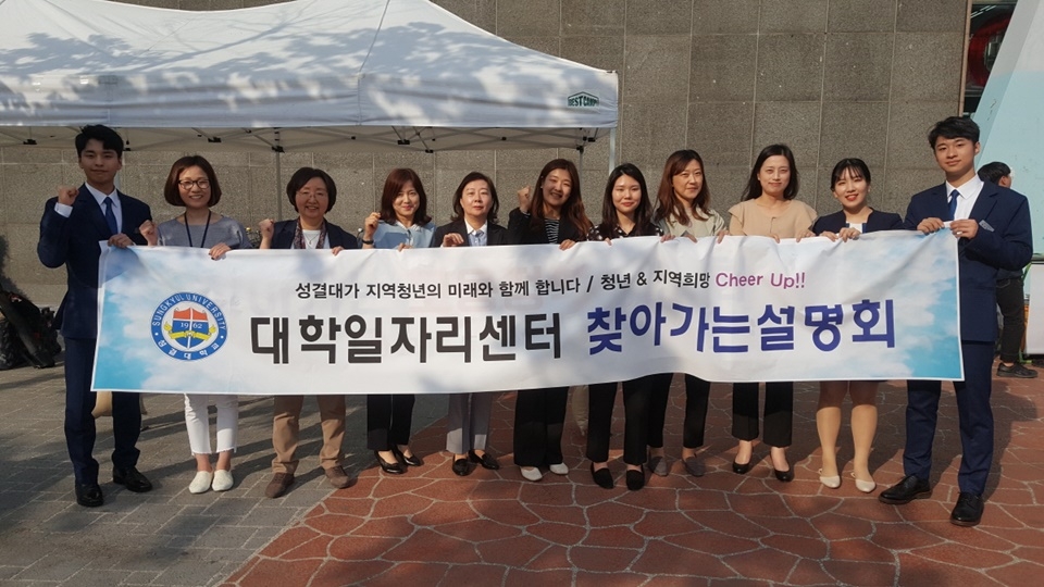 안양역 광장에서 성결대 대학일자리센터 관계자, 홍보대사 블루인과 고용노동부 안양지청관계자들이 단체사진을 촬영하고 있다.