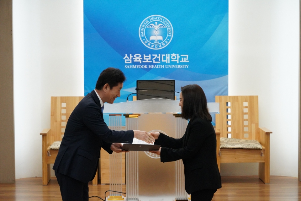 13일 시상식에서 김소연 교수(오른쪽)에게 교육부장관 표창을 전달하고 있는 박두한 총장.