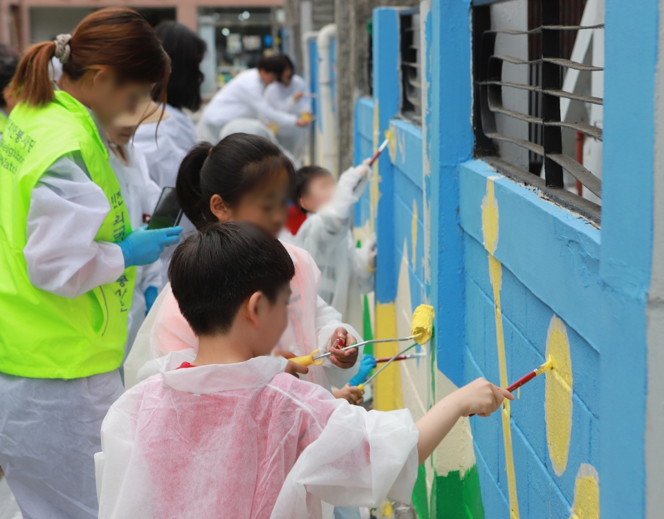 18일 인천 미추홀구 용현동에서 지역 주민과 학생들이 벽화그리기 봉사활동을 하고 있다.