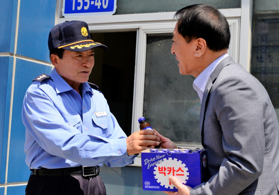 김선재 총장이 17일 대학 발전기금을 전달한 경비원 조동 씨에게 음료를 전달하고 있다.