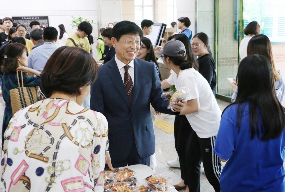 박승호 총장이 직접 도서관을 찾은 학생들에게 간식을 나눠주며 격려하고 있다.