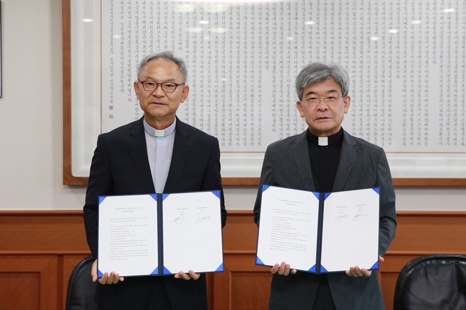김정우 대구가톨릭대 총장(오른쪽)과 정일 가톨릭상지대학교 총장이 교류협정을 체결하고 협약서를 보이고 있다.