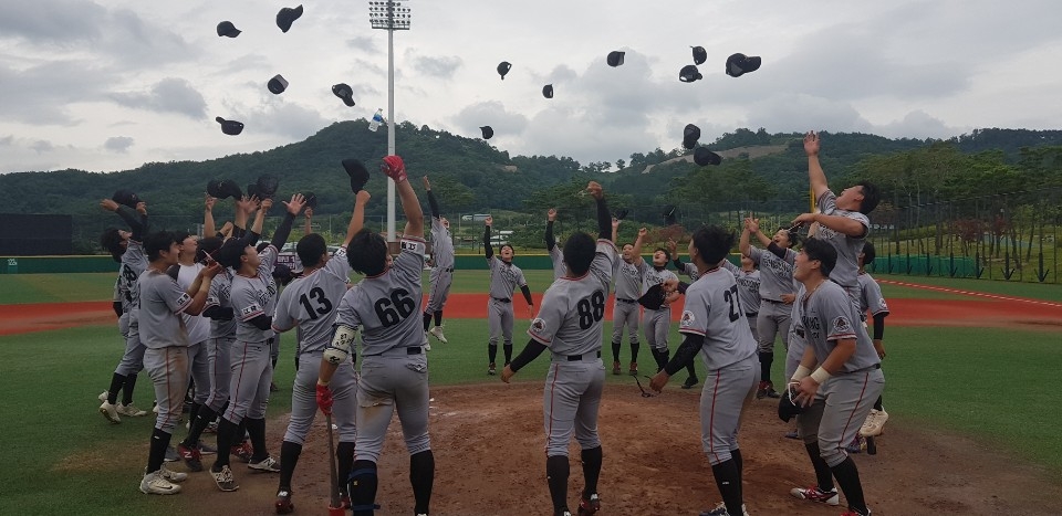 강릉영동대학교 야구부 선수들이 우승 확정 후 모자를 던지며 환호하고 있다.