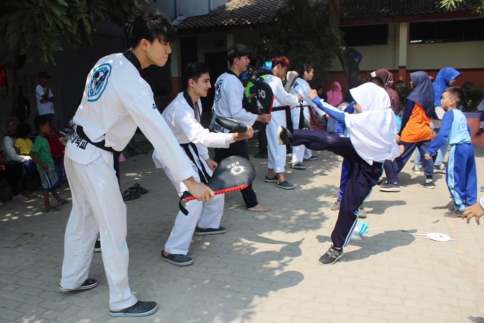 인도네시아 국외봉사단이 현지학생들에게 태권도 발차기를 가르치고 있다.