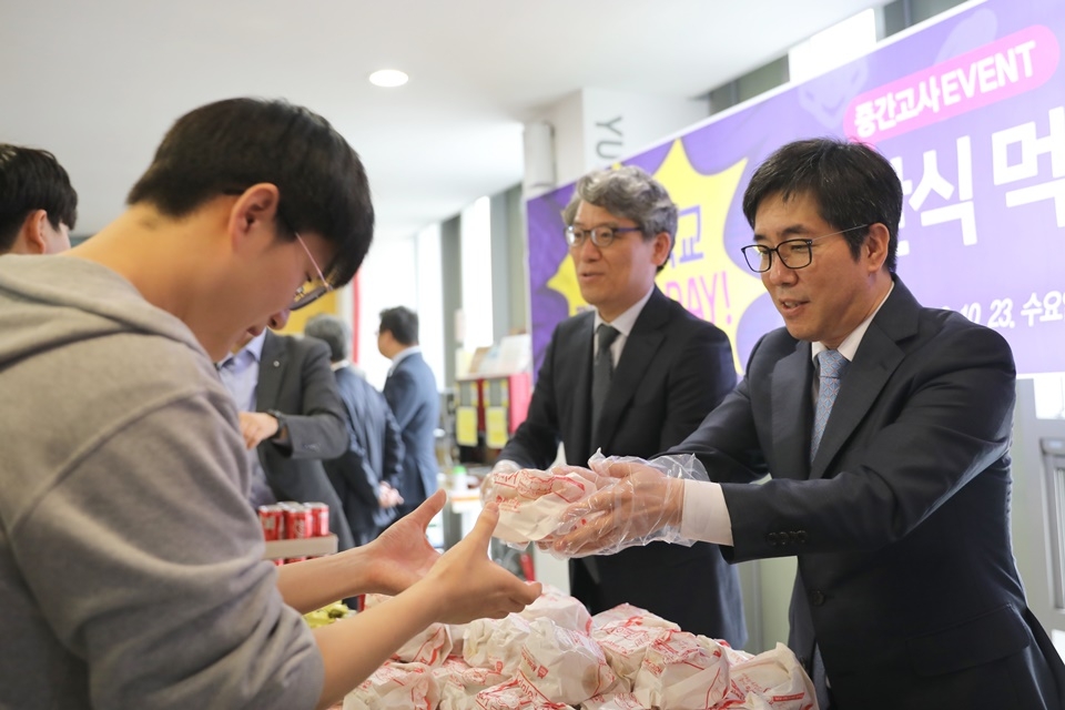 김현중 총장이 학생들에게 간식을 나눠주고 있다.