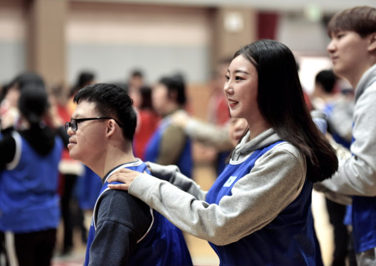 인천재능대학교 사회복지과 학생들과 지역사회 성인장애인들이 서로 어깨를 풀어주고 있다.