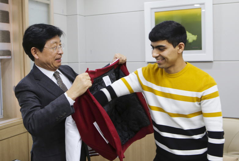 박승호 계명문화대학교 총장이 아미르혼(타지키스탄) 학생에게 직접 겨울점퍼를 입혀주고 있다.