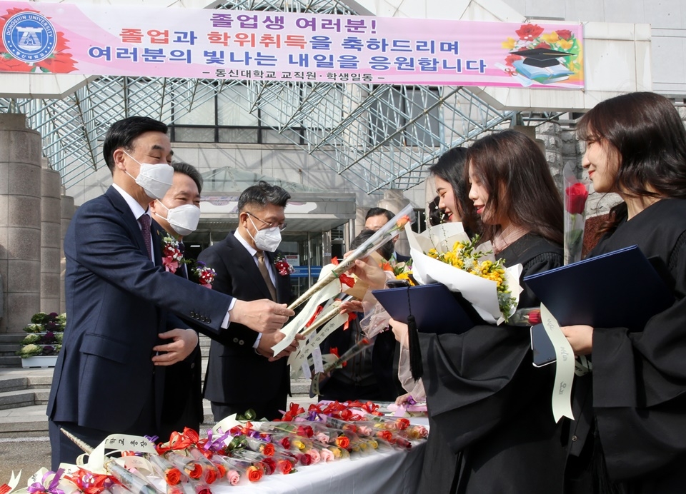 최일 총장(맨 왼쪽)이 졸업생들에게 장미꽃을 나눠주고 있다.