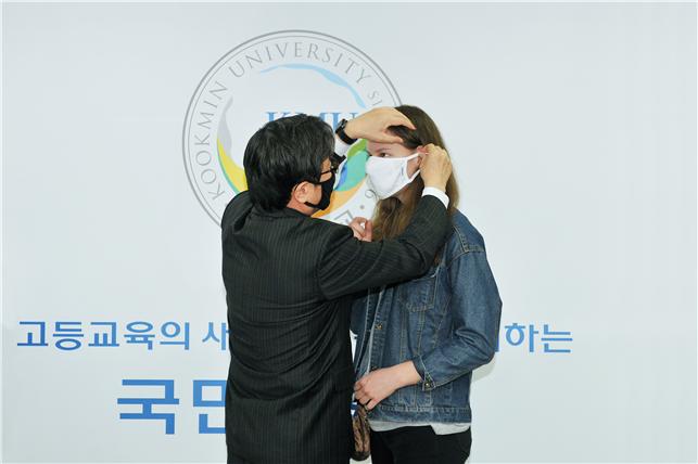 임홍재 총장이 외국인 유학생에게 마스크를 씌워주고 있다.