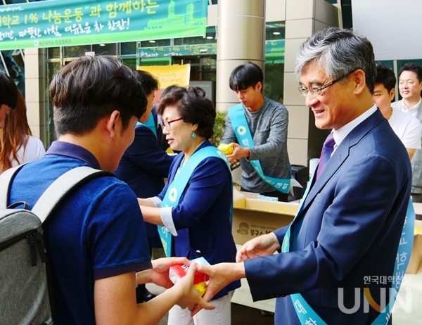 홍덕률 이사장이 대구대 총장이던 2017년 학생들에게 간식을 나눠주고 있는 모습.(사진=한국대학신문 DB)