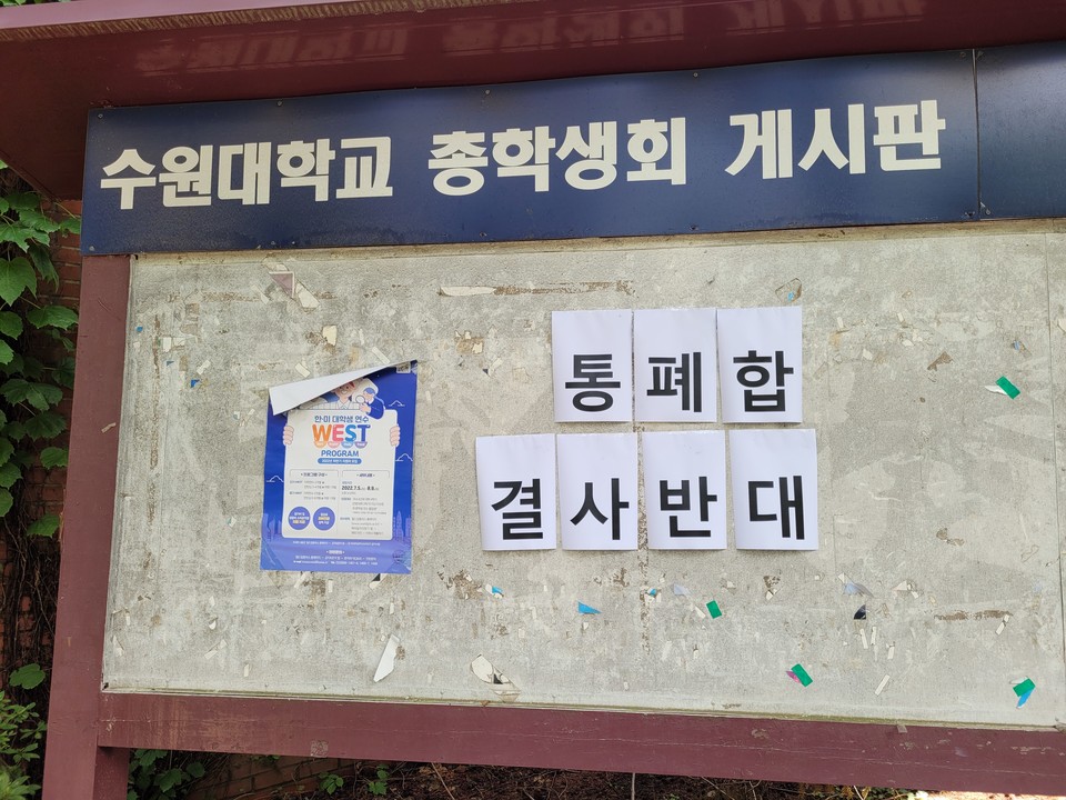 14일 수원대 교내 게시판에 붙어 있는 대자보. 두 학교의 통폐합을 반대한다는 내용이 적혀있다. (사진=김한울 기자)