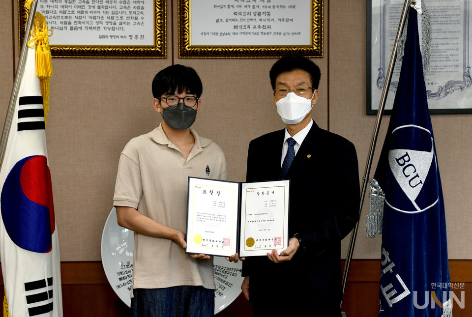 박세중 씨가 송기신 총장(오른쪽)으로부터 표창장과 장학증서를 수여받고 있다.