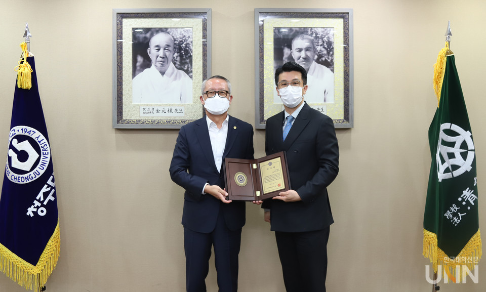 차천수 청주대 총장이 발전기금을 기탁한 ㈜에프앤디홀딩스 조성준 대표이사에게 감사패를 전달한 후 기념촬영을 하고 있다.