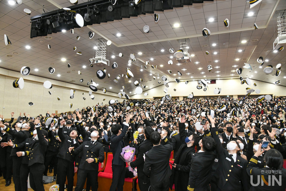 해사대학 졸업식 모습. 졸업생들이 모자를 던지고 있다.