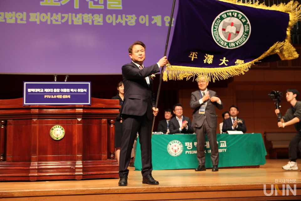 이동현 총장이 취임식에서 교기를 흔들고 있다.