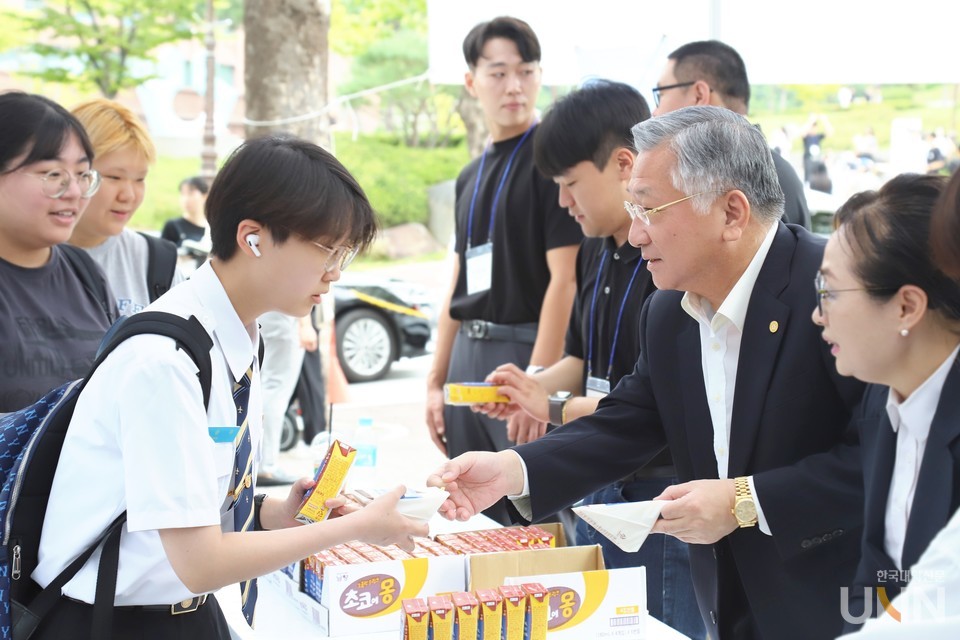 김윤배 총장과 학생회 간부들이 학생들에게 간식을 나눠주고 있다.