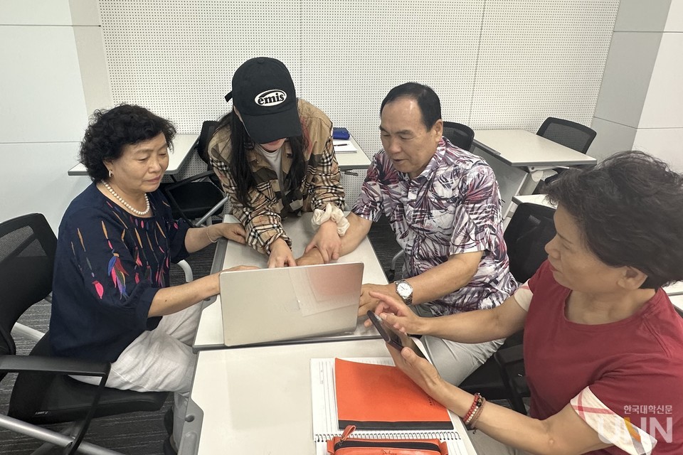 오산대 ‘디지털 요원’이 성인학습자들에게 노트북, 스마트폰에서 교내 LMS에 로그인하는 방법을 알려주고 있다. 학습자별로 이해 속도가 달라 디지털 요원이 한 사람씩 단계별로 알려주고 있는 모습이다. 노트북 활용법을 빠르게 이해한 학습자는 스마트폰에서 스스로 방법을 찾아보는 모습도 보인다. (사진=오산대 제공)