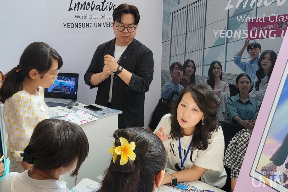 대학 관계자가 통역사와 함께 일대일 상담을 펼치고 있다. 부스 한쪽에는 대학 홍보 영상이 재생되고 있으며 한쪽에는 대학 정보를 한눈에 볼 수 있는 홍보 배너가 마련돼 있다. (사진=주지영 기자)