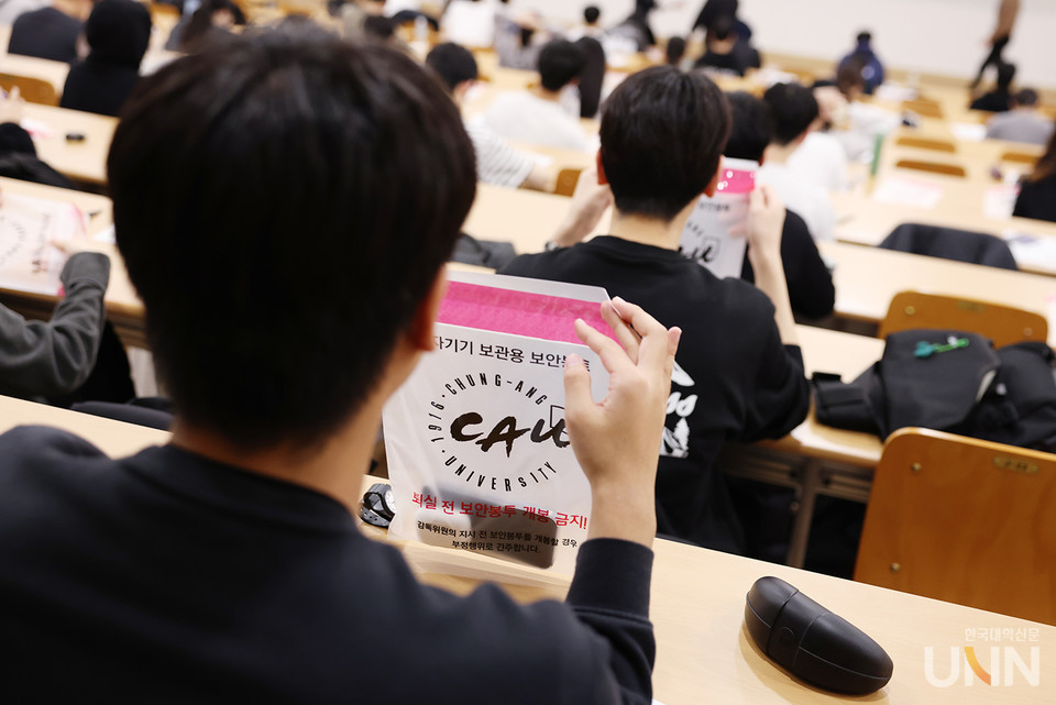 중앙대는 논술고사 시 전자기기 보관용 보안봉투를 통해 전자기기 사용을 미연에 방지한다. 논술고사에 참여한 수험생이 안내에 따라 전원을 끈 전자기기를 보안봉투에 넣고 있다.