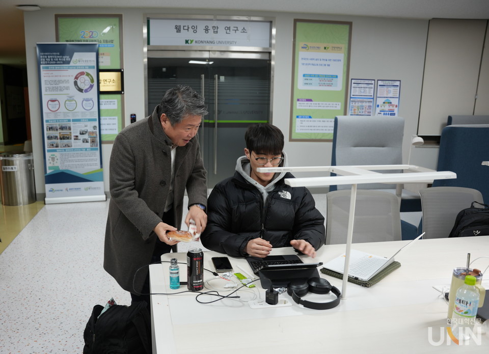 김용하 총장이 새벽 4시에 학생들에게 빵을 나눠주고 있다.