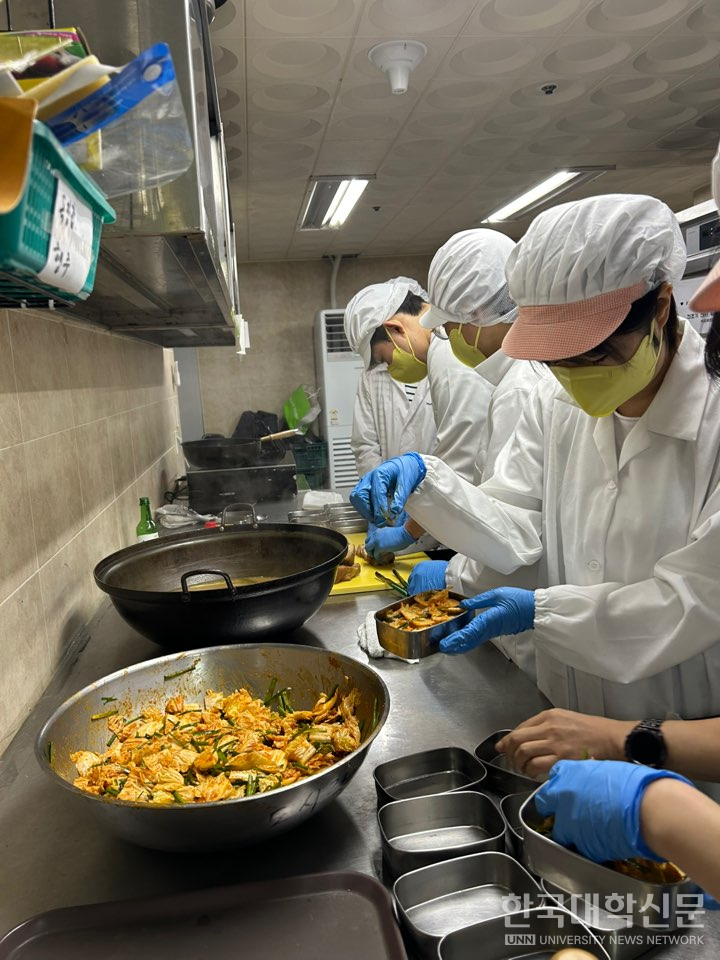 학생들이 조리한 음식을 도시락에 담고 있다.