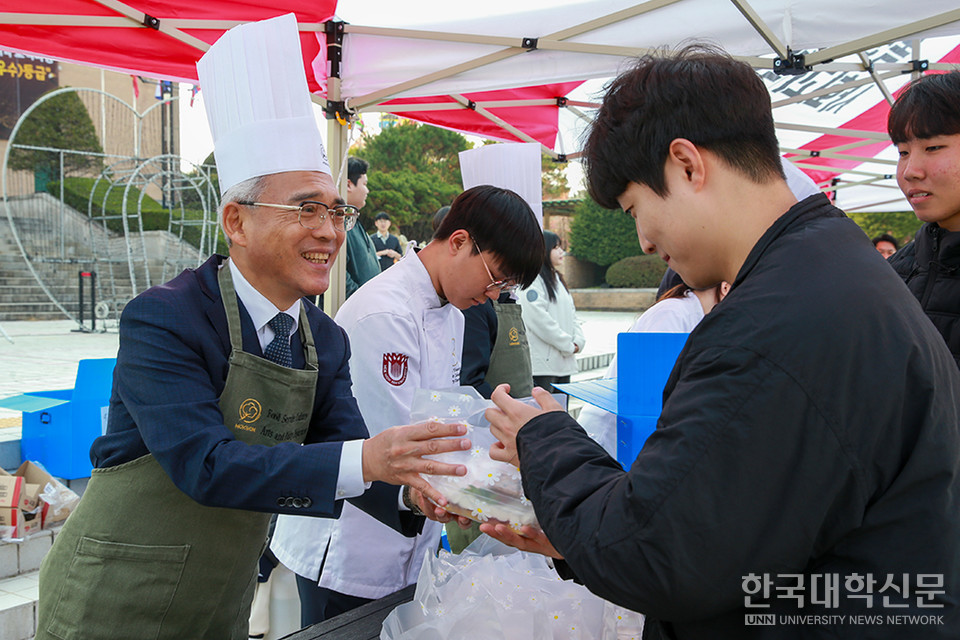 24일 정오 목원대 중앙도서관 앞 진리의광장에서 이희학 총장(왼쪽)이 한 학생에게 간식 꾸러미를 전달하고 있다.